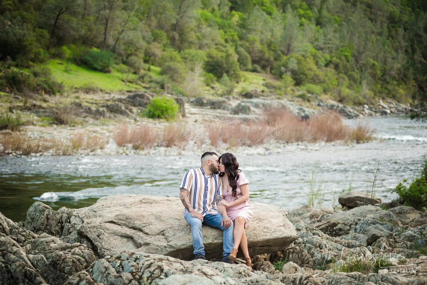 A couple sitting beside the river