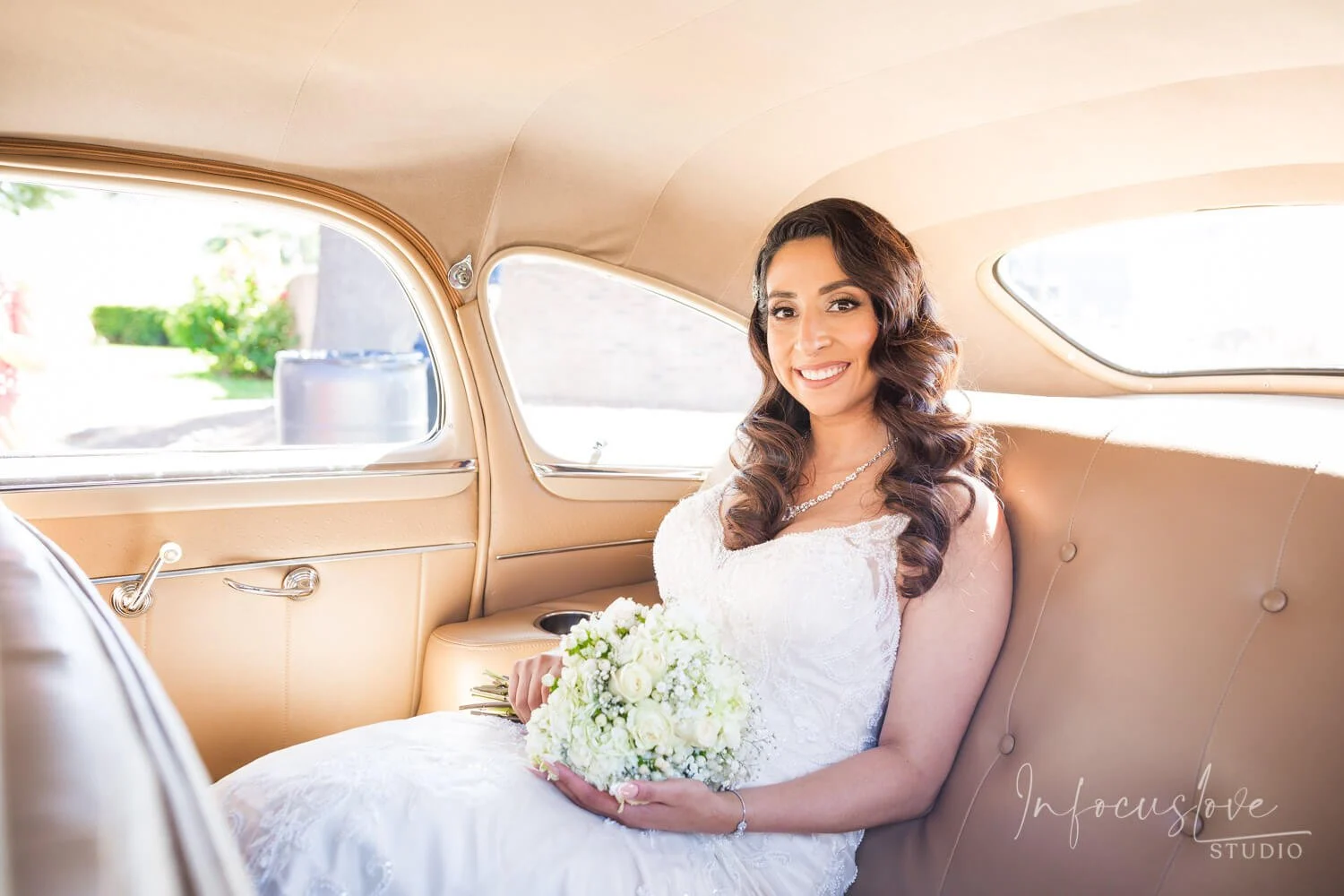 A bride seated in a vintage car