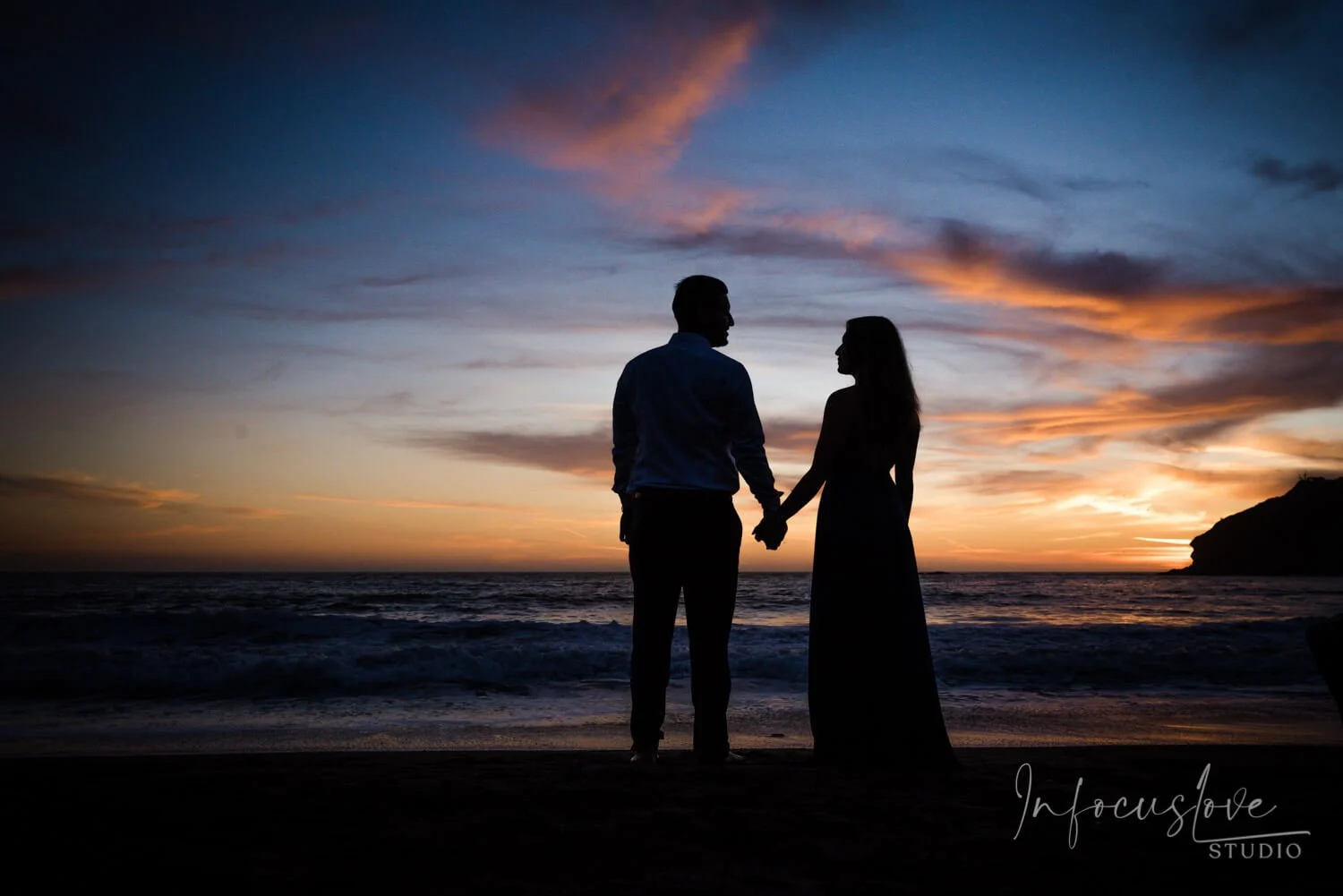 A couple silhouetted against a sunset
