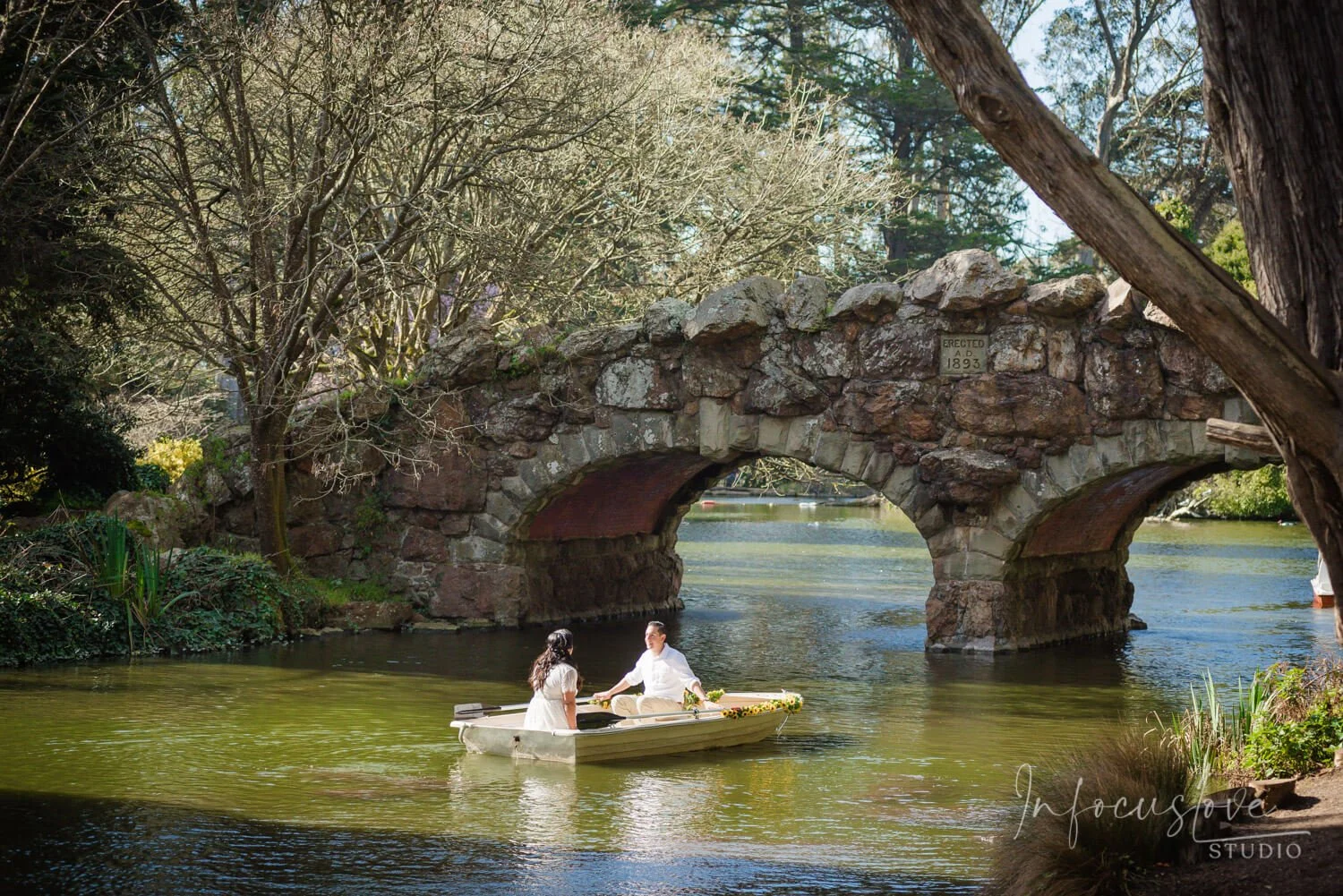 A couple paddling beneath an arched bridge